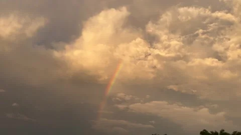 Rainbow Over Dramatic Cumulus Clouds at Evening Sunset Stockbeeldmateriaal 296002719
