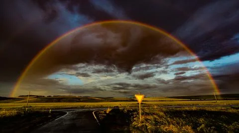 Rainbow over the evening field Stock Photos