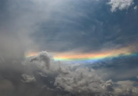 Rainbow over grey cloudy sky Stock Photos