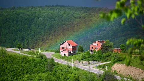 Rainbow over houses in mountain. Stock Footage 311978950