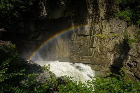 Rainbow over Isel river waterfall in Pragraten Austria sunny summer atmospher Stock Photos