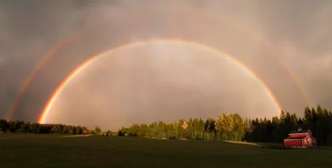 Rainbow over red barn Stock Photos