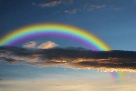 Rainbow over sunset sky back silhouette cloud 库存照片