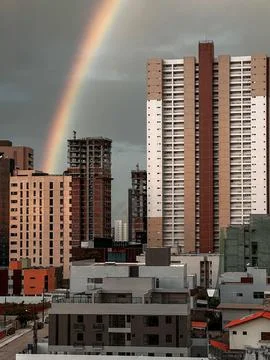 Rainbow over urban buildings Stock Photos