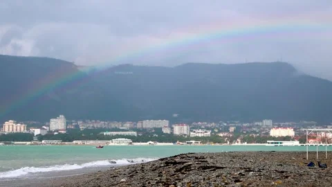A rainbow over a winter pebble beach after a storm. In the background there are Stock Footage 256462595