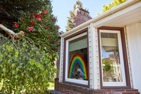 A rainbow painted on the front window of a home in Portland, OR. Stock Photos