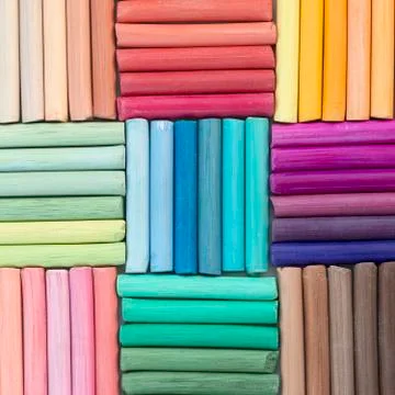 Rainbow pastel crayons in rows as background. Square image Stock Photos