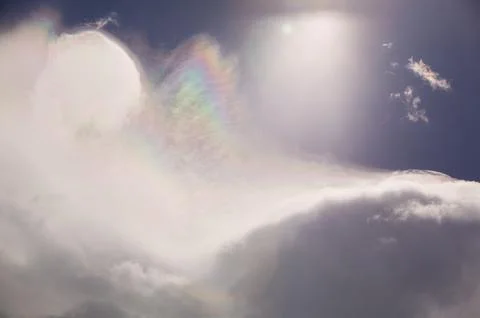 Rainbow patterns on ice crystals in high cloud above switzerland Stock Photos