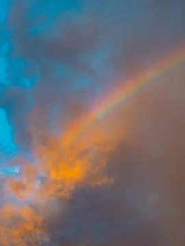 Rainbow Piercing Through Orange and Blue Sunset Clouds, Dramatic Sky Stock Photos