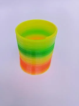Rainbow plastic coil spring toy on white background Stock Photos