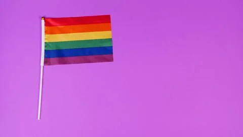 Rainbow pride flag on purple background. Stock Photos