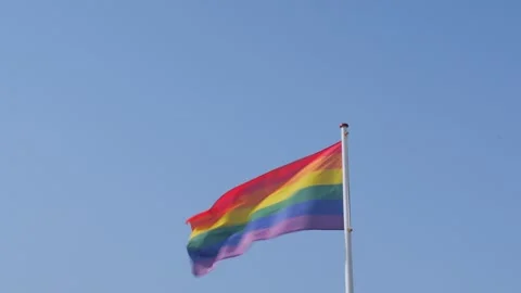 Rainbow Pride Flag Waving Against Clear Blue Sky Stock Footage 341802412
