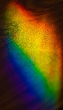 A rainbow projected on a tabletop with light through a display case in an off Stock Photos