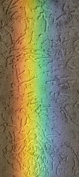 Rainbow projected onto a wall inside a house through the glass door opposite, Stock Photos