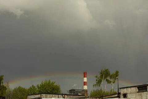 Rainbow in rainy sky. Celestial landscape in industrial area. Foto stock