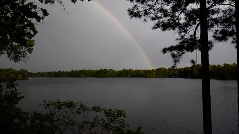 Rainbow reaches to touch the other side of the lake. Stock-Footage 94155719