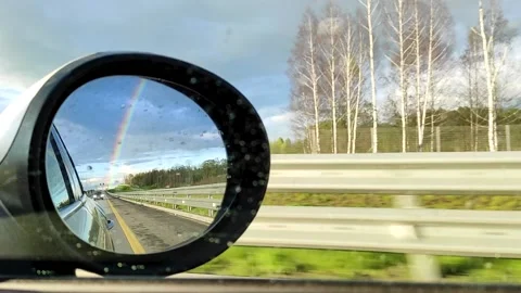 Rainbow in the rearview mirror of a car after rain. High quality FullHD footage Stock Footage 221932285