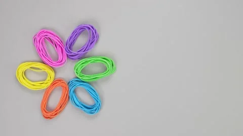 Rainbow rubber bands in shape of flower on grey background. Bright flower from Stock Footage 231587506