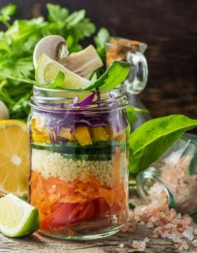 Rainbow salad in a jar of layers of different vegetables, mushrooms and her.. Stock Photos