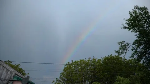 Rainbow in the sky against a background of dark clouds on a summer evening Stock Footage 132711967