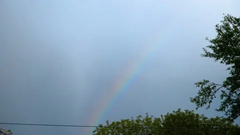 Rainbow in the sky against a background of dark clouds on a summer evening Stockbeeldmateriaal 132712093