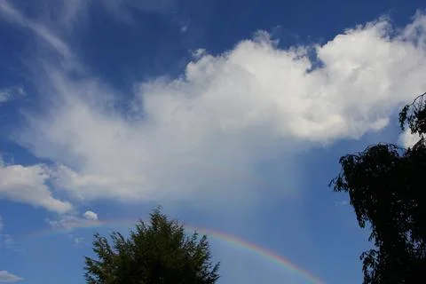 Rainbow in the Sky with Clouds Stock Photos