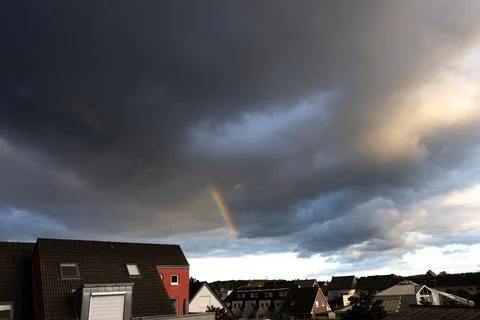 Rainbow in the sky with thunderclouds over the city Foto stock