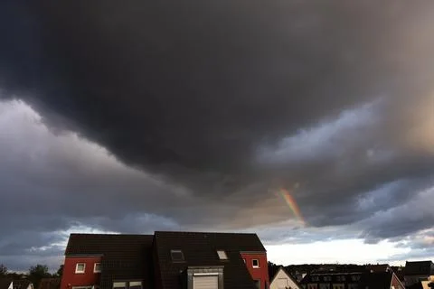 Rainbow in the sky with thunderclouds over the city Stock Photos