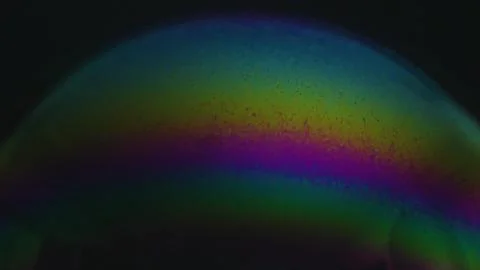 Rainbow soap bubble on a dark background. Close-up of colorful surface Illustrazione stock