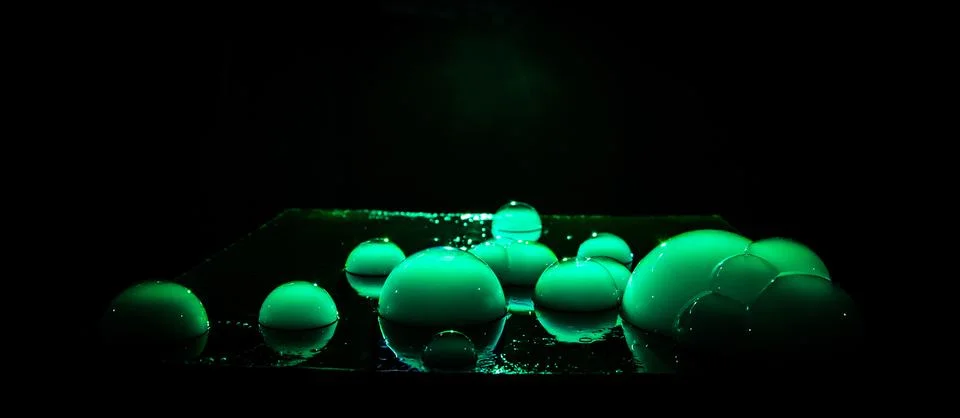 Rainbow soap bubbles on a dark background. Abstract wet surface with fog and  Stock Photos