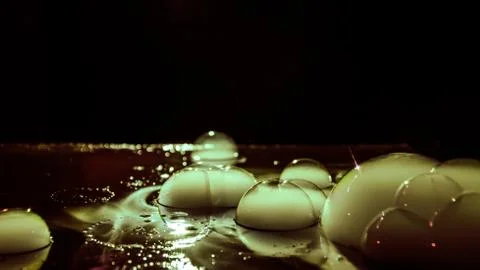 Rainbow soap bubbles on a dark background. Abstract wet surface with fog and  Stock Photos