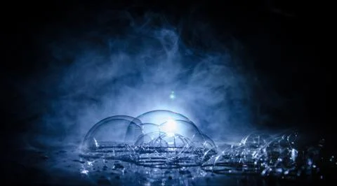 Rainbow soap bubbles on a dark background. Abstract wet surface with fog and  Stock Photos
