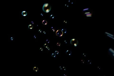 Rainbow soap bubbles on a dark background. Stock Photos