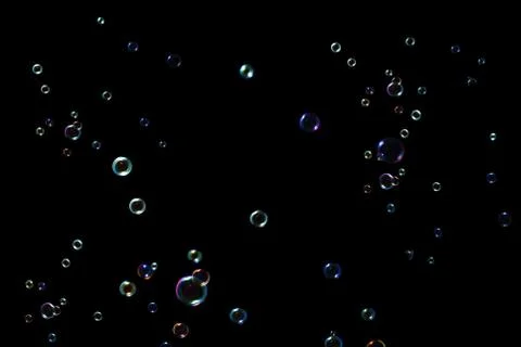 Rainbow soap bubbles on a dark background. Stock Photos