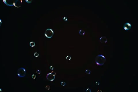 Rainbow soap bubbles on a dark background. Stock Photos