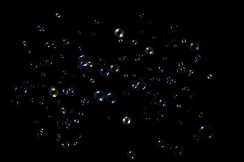 Rainbow soap bubbles on a dark background. Stock Photos
