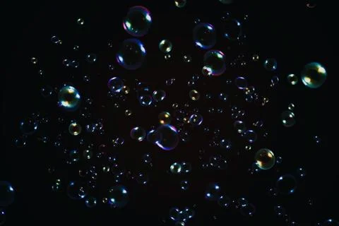 Rainbow soap bubbles on a dark background. Stock Photos
