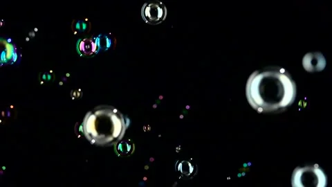 Rainbow soap bubbles fly. Slow motion. Black background Stock Footage 98006652