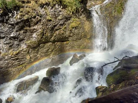 Rainbow in splashes of water over a small waterfall in the Austrian Alps Stock Photos