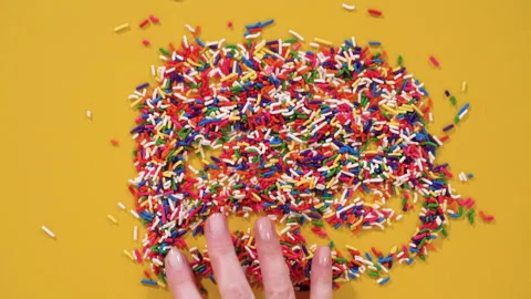 Rainbow Sprinkles Arranged in Circle on Yellow Surface Stock Footage 325080807