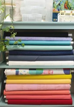 Rainbow stack of quilt fabric bolts Stock Photos