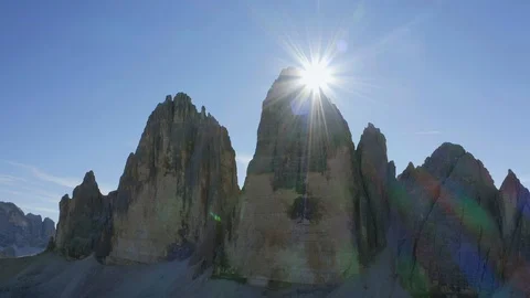 Rainbow sunrays behind the Three Peaks  of Lavaredo Mountains Stock Footage 128963570