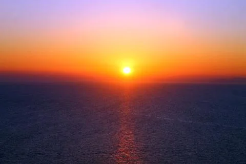 A rainbow sunset over the colored ocean Stock Photos
