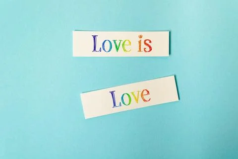 Rainbow Text Love Message on Blue Background Stock Photos