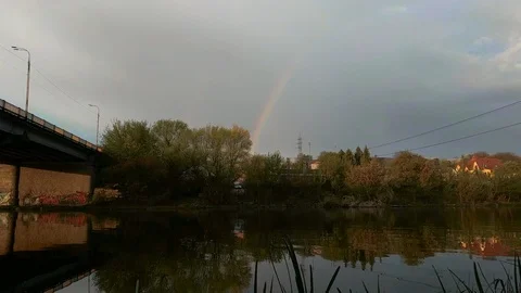 Rainbow with trees covering and moving sky Stock Footage 121835656