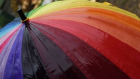 Rainbow umbrella in the rain on a green background Stock Footage 91198145