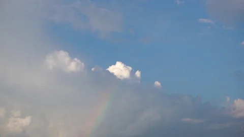Rainbow under rain clouds against blue sky Stock Footage 91702342