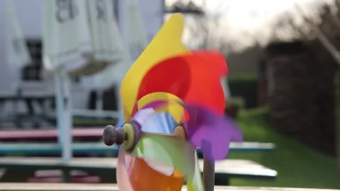 Rainbow windmill toy blowing and spinning in the wind 库存影片 147536931