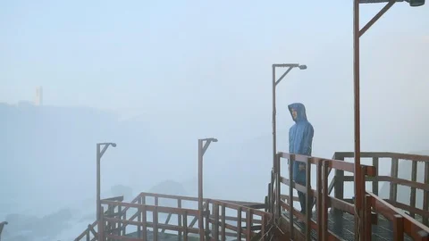 Raincoat man at waterfall Stock Footage 88000864