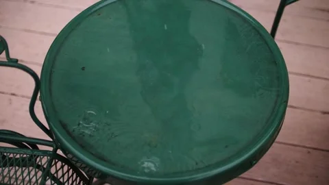 Raindrop falling splashing on green table and slow motion water puddle Stock Footage 205956768